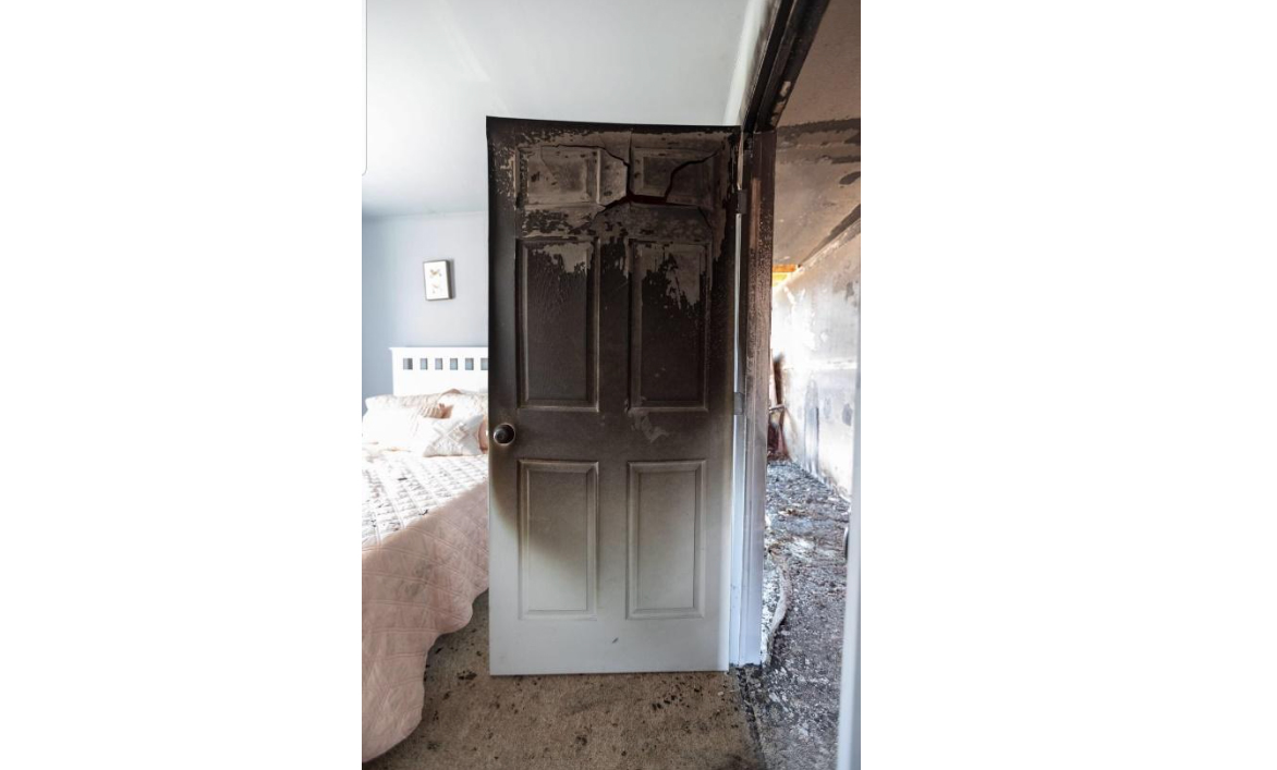 This bedroom door was closed during a fire. You can see the damage to the door and hallway. The bedroom is clean and untouched. Always keep your bedroom door closed when sleeping.